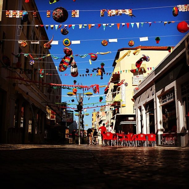 architecture, built structure, building exterior, low angle view, city, hanging, street, red, communication, flag, sky, building, lantern, residential building, outdoors, city life, incidental people, day, in a row, text