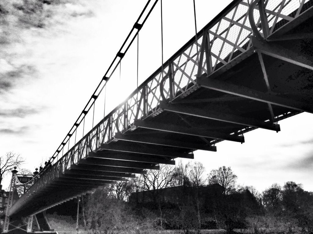 sky, low angle view, connection, built structure, architecture, metal, bridge - man made structure, metallic, cloud - sky, engineering, transportation, cloud, tree, rusty, day, no people, outdoors, cloudy, bridge, iron - metal