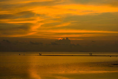 Scenic view of sea against cloudy sky during sunset