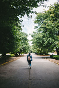 Rear view of man walking on road in city