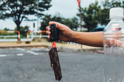 Cropped hand holding purse with equipment