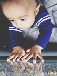 Close-up of cute boy touching window glass