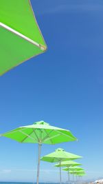 Low angle view of umbrella against clear blue sky