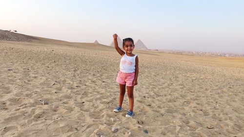 Full length of girl standing in desert of pyramids