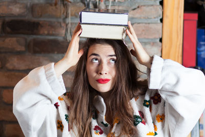 Young woman carrying books on head