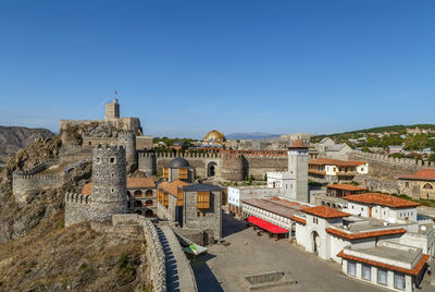 View of buildings in city against clear blue sky