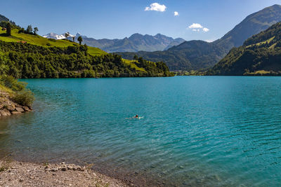 Scenic view of sea and mountains against blue sky