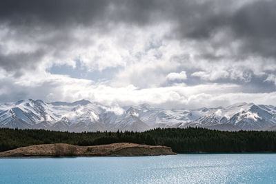 Gloomy landscape of new zealand southern alps and lake pukaki with blue sky and clouds.