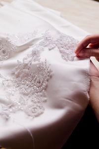 Cropped hand of woman stitching wedding dress