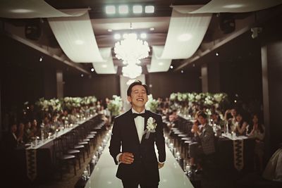 Smiling man wearing suit walking in illuminated room