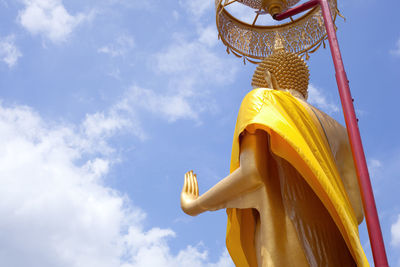 Low angle view of buddha statue against sky