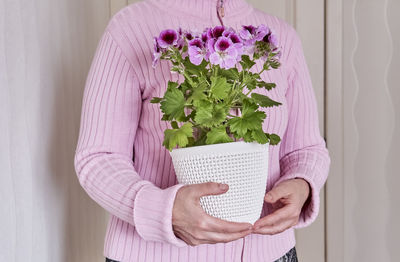 Close-up of woman holding pink flower