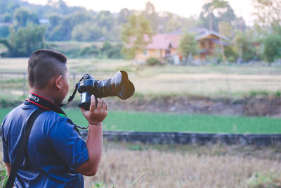 Man photographing on field