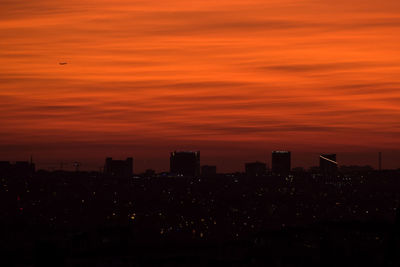 Silhouette buildings against sky during sunset