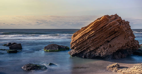 Scenic view of rocks in sea against sky