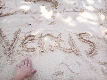 High angle view of word written on sand next to wall