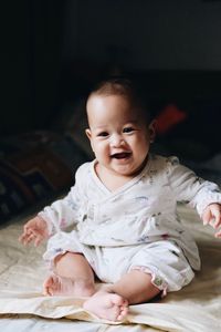 Portrait of smiling cute baby girl sitting at home