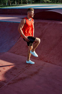 Full length portrait of young man with arms raised