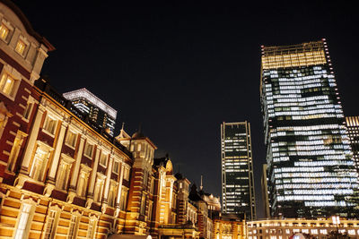 Low angle view of illuminated buildings against sky at night