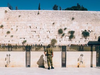 Rear view of soldier looking at wailing wall