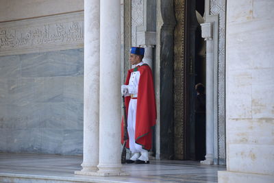 Side view of man standing by building