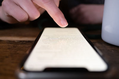 Midsection of person using smart phone on table