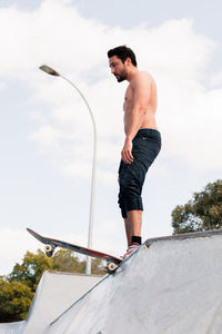 Young skater standing at the top of the skate ramp