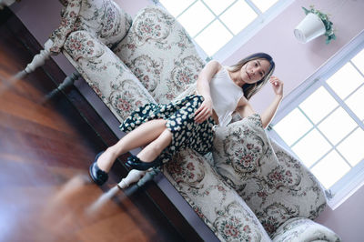 Young woman sitting on sofa at home