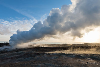 Smoke emitting from sea against sky