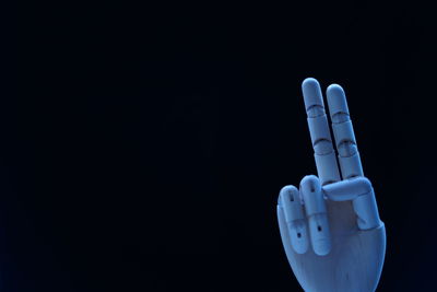 Close-up of artificial hand against black background