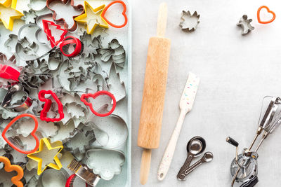 A baking tray filled with cookie cutters with other baking tools to the right.