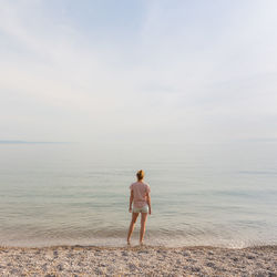 Rear view of woman standing on beach