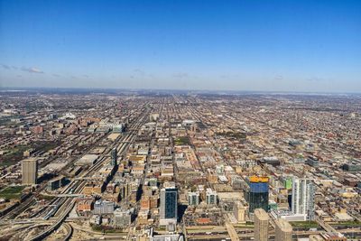 High angle view of city buildings against blue sky