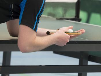 Midsection of man playing table tennis