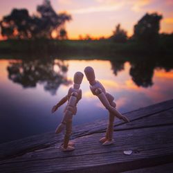 Full length of wooden pier on lake against sky during sunset