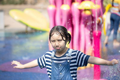Portrait of girl standing at fountain in park