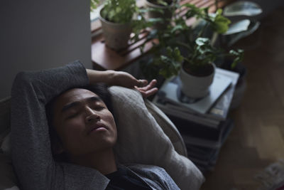 Sad man facing depression lying in bed