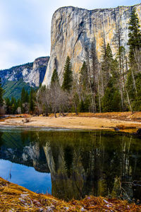 Scenic view of lake , forest and tall mountain  granite rock face reflecting on crystal clear lake