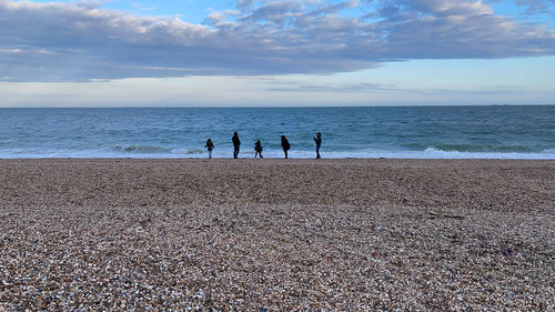 People on beach against sky