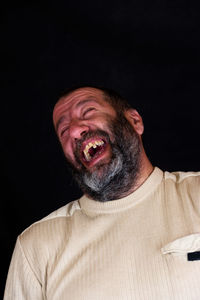 Portrait of smiling man against black background