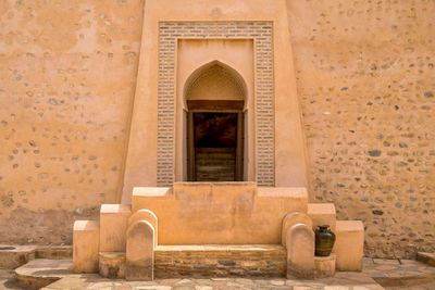 Ancient door with ornaments around it in a wall of medieval arabian fortress. 