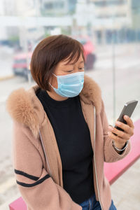 Midsection of woman using mobile phone