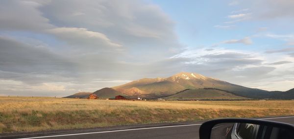 Road by landscape against sky