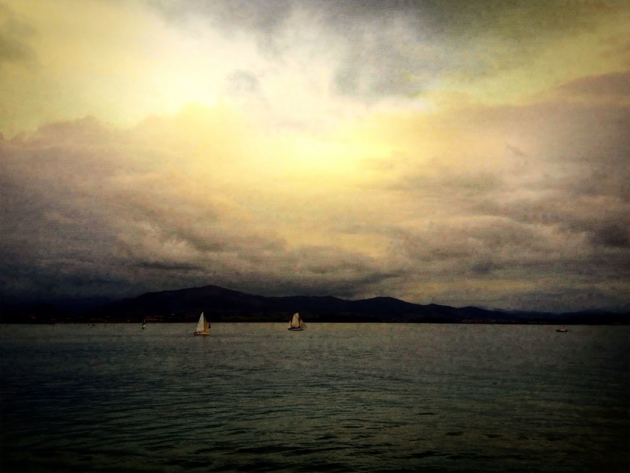 SCENIC VIEW OF SEA AGAINST CLOUDY SKY AT SUNSET