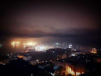 High angle view of illuminated city against sky at night