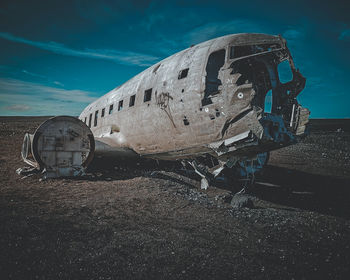 Abandoned airplane on airport runway against sky