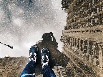 Low section of person standing in puddle