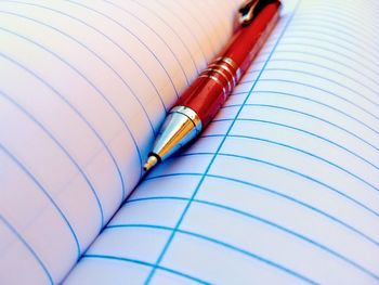 Close-up of pen on blank book