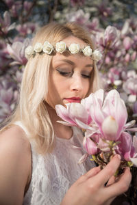 Beautiful woman smelling flower