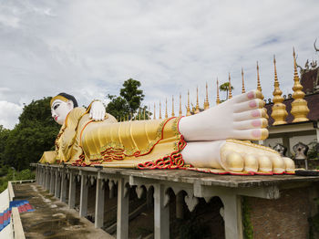 Statue against temple and building against sky